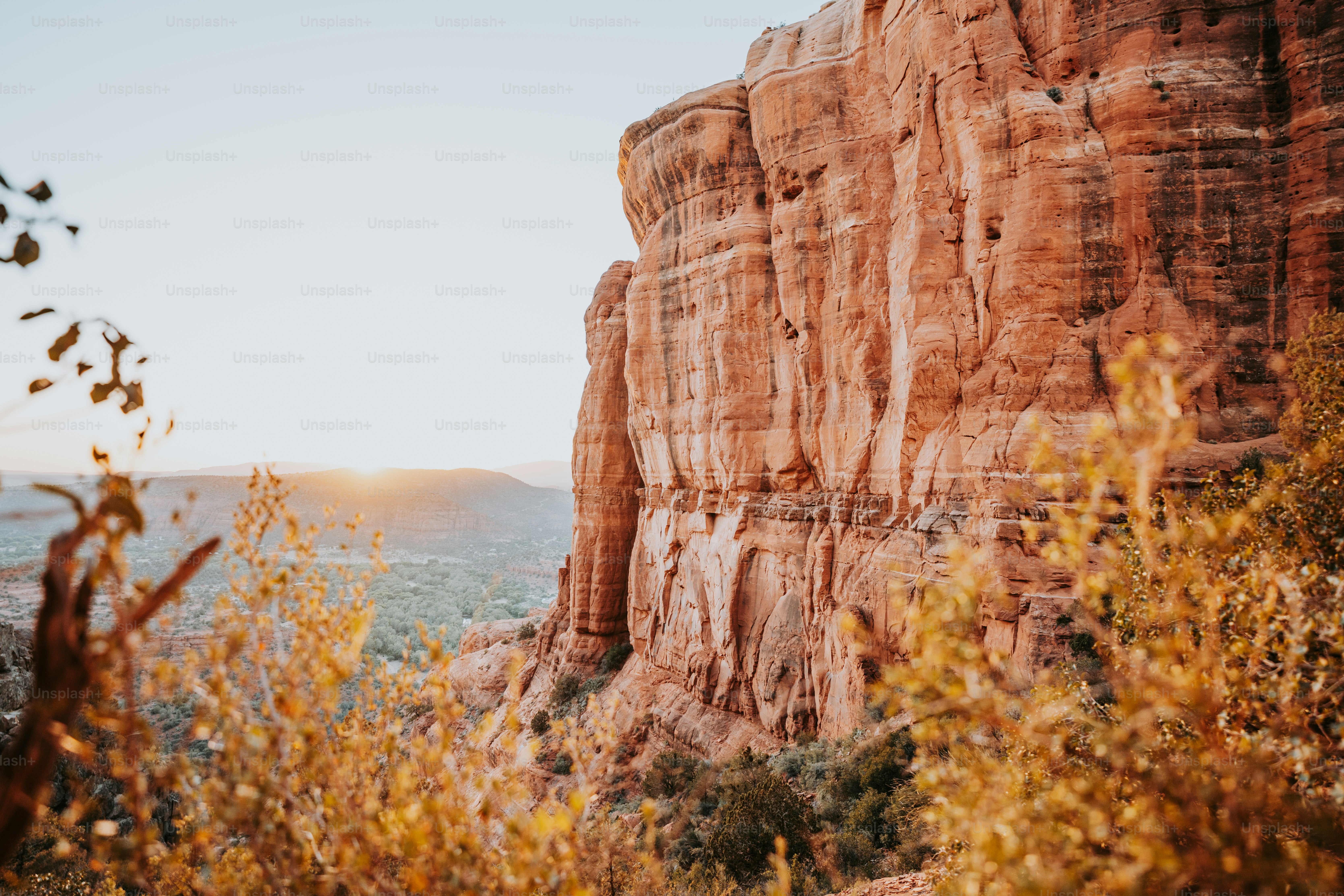 the sun is setting on a rocky cliff