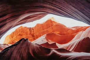 a view from inside a cave looking up at the mountains