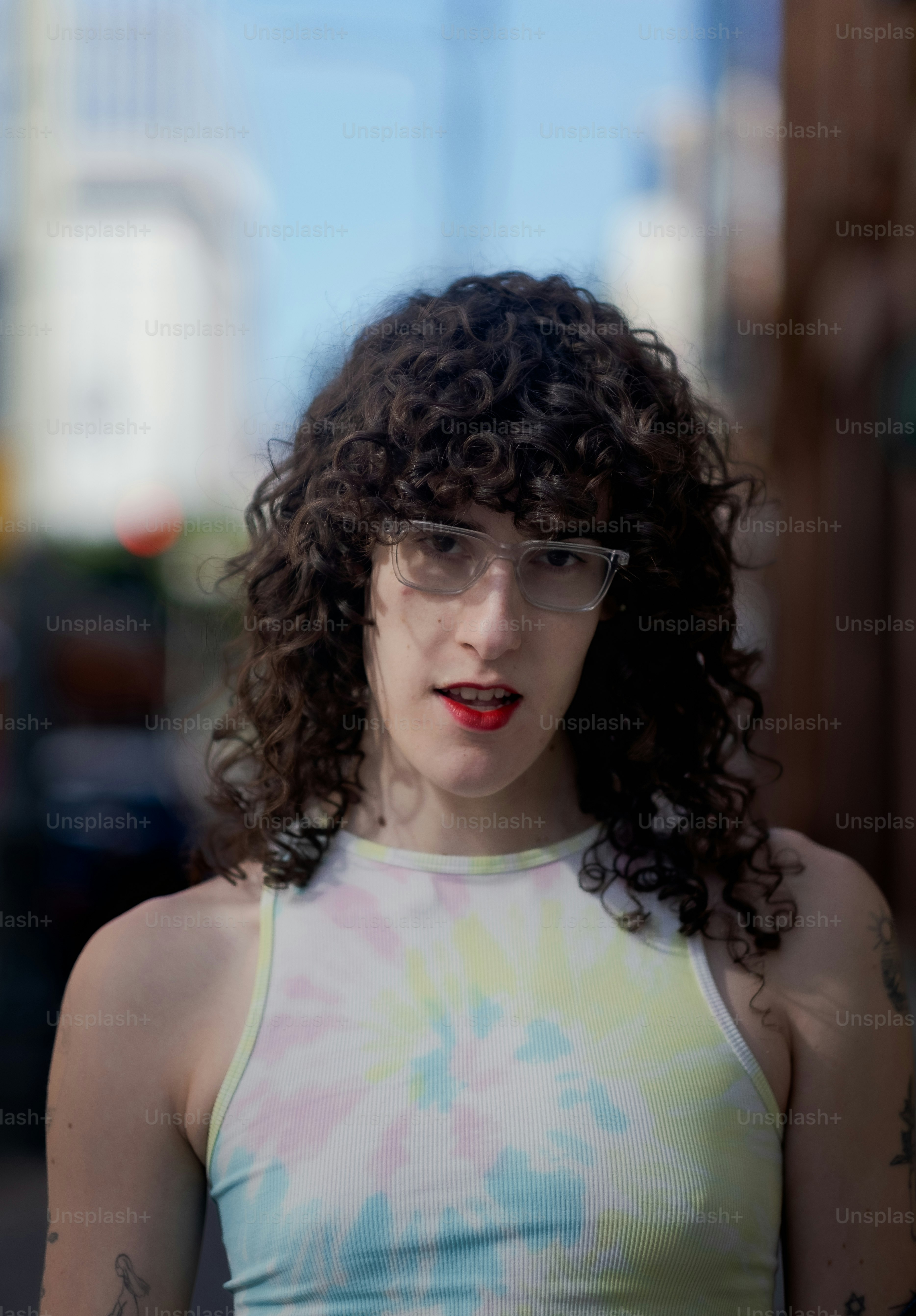 A woman wearing glasses and a tie dye tank top photo Transgender