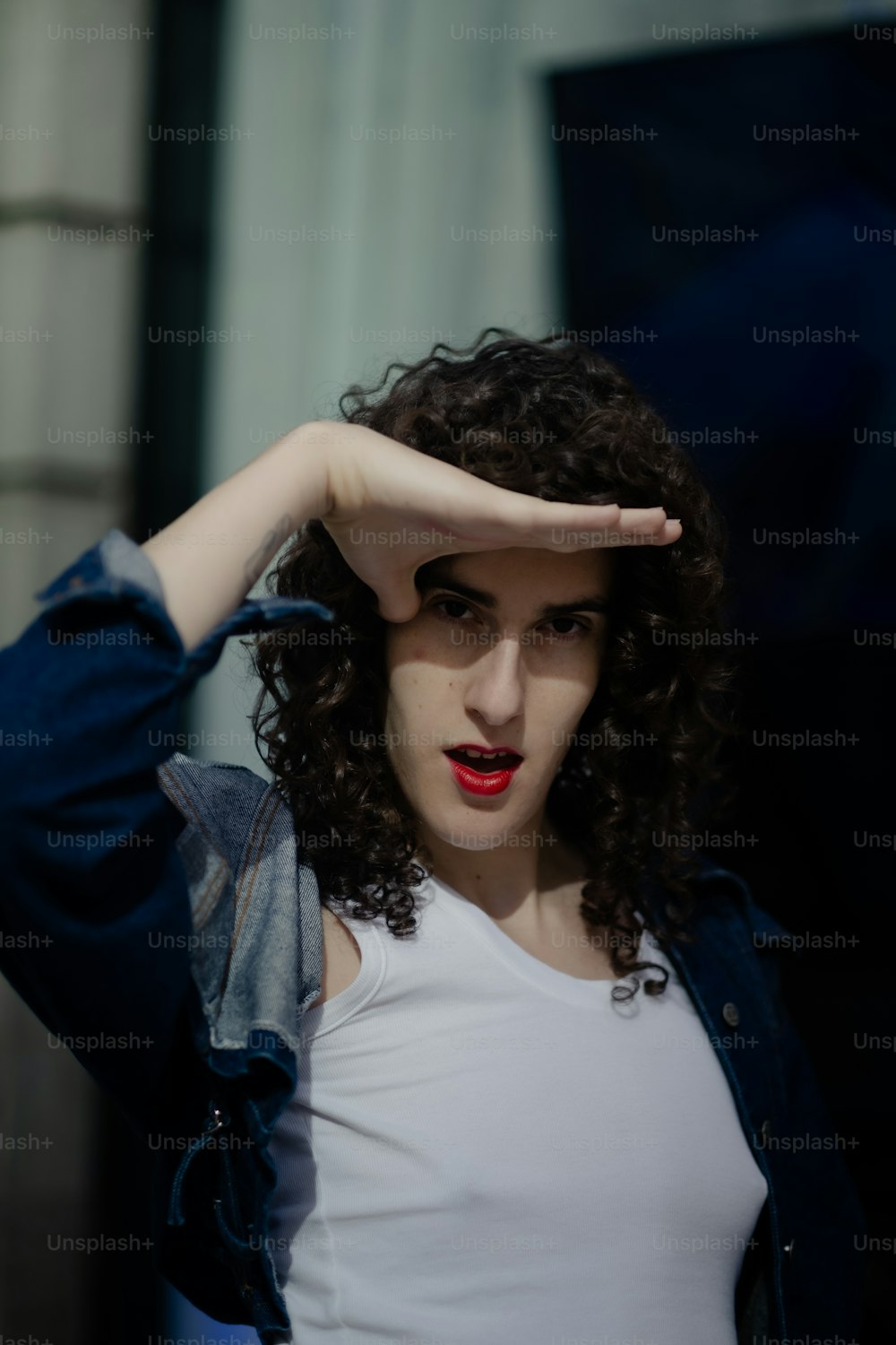 a woman with curly hair covering her eyes