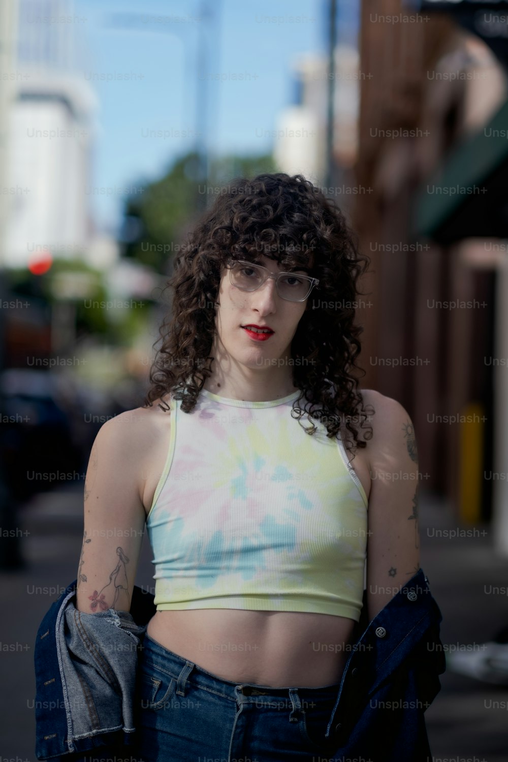 a woman in a crop top is standing on the street