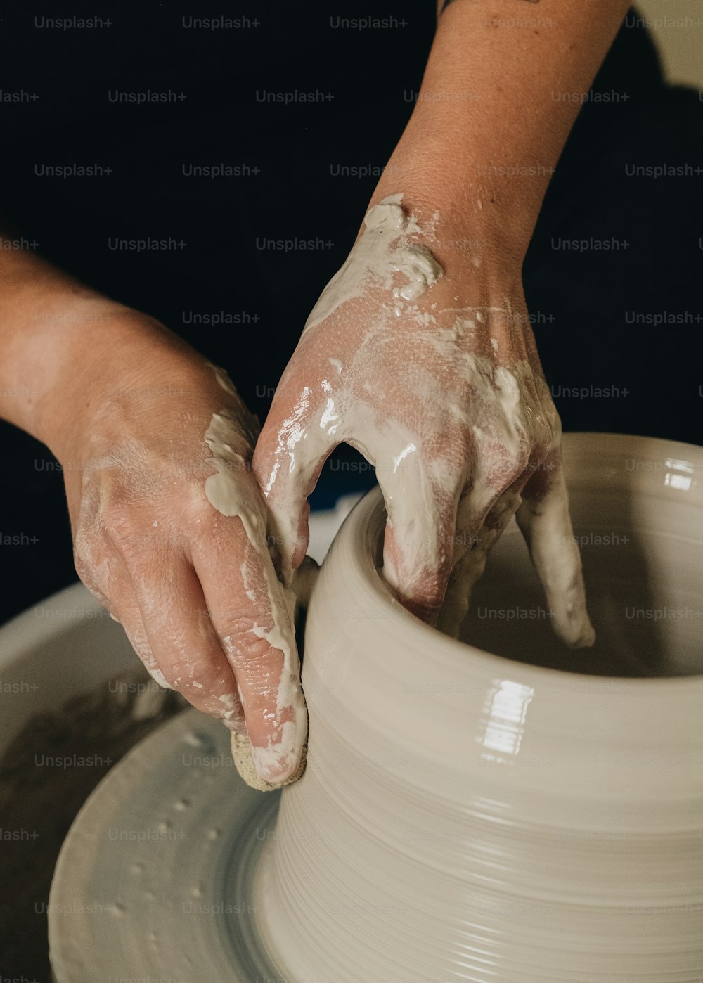 a person is making a pot on a potter's wheel