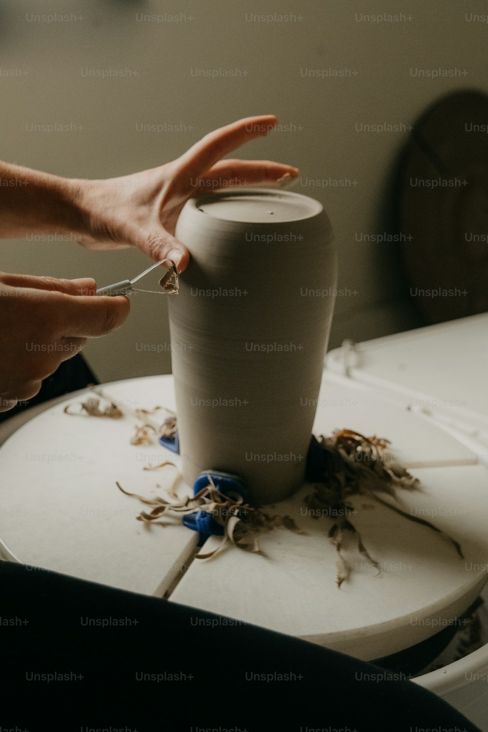 a person is making a vase out of clay