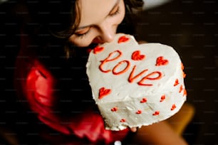 a woman biting into a heart shaped cake