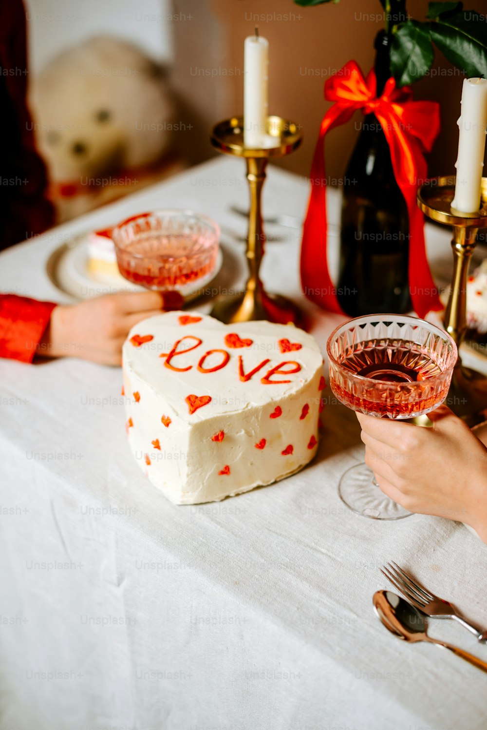 a table topped with a cake and two glasses of wine