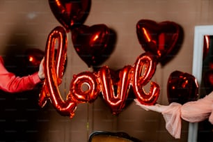 a woman holding a red balloon that says love
