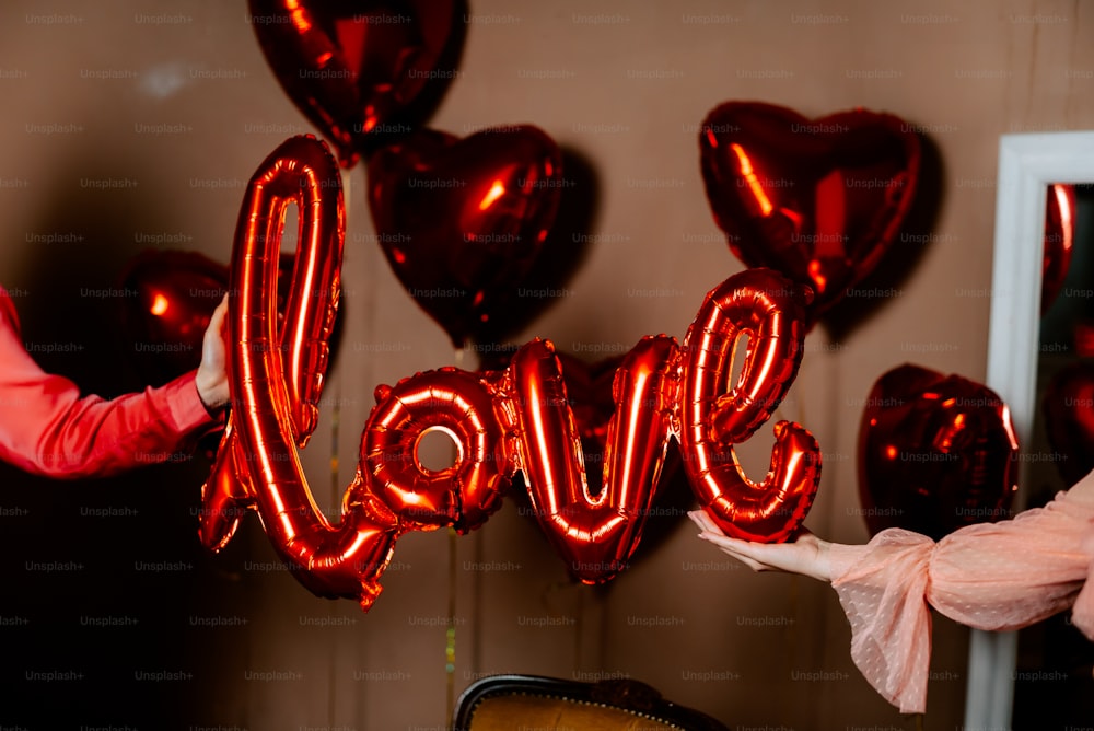 a woman holding a red balloon that says love