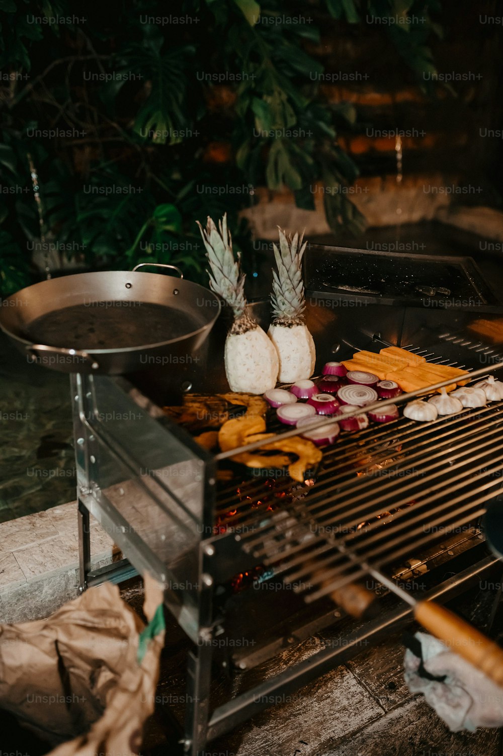 a grill with onions, onions, and pineapples cooking on it