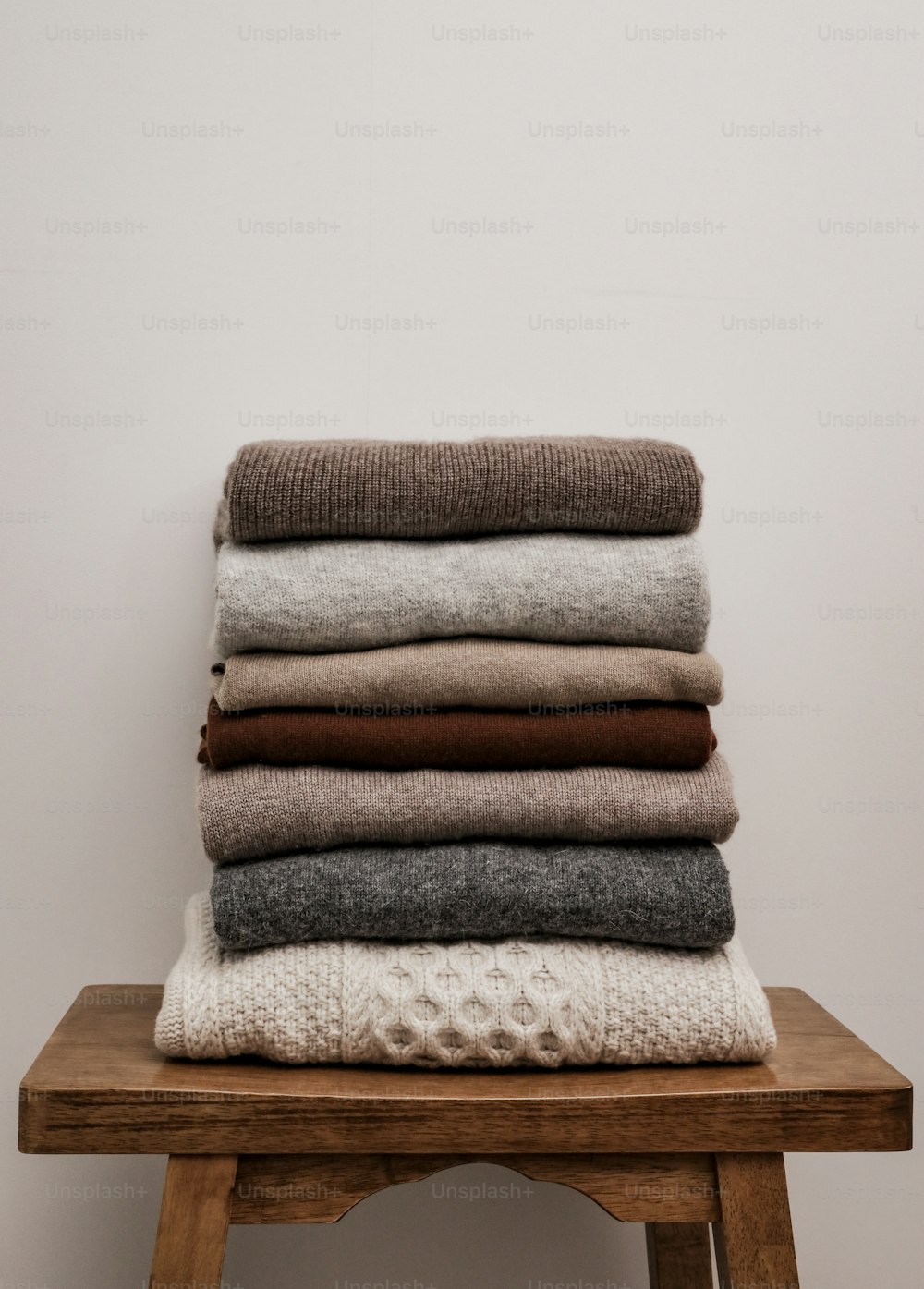 a stack of folded blankets sitting on top of a wooden table