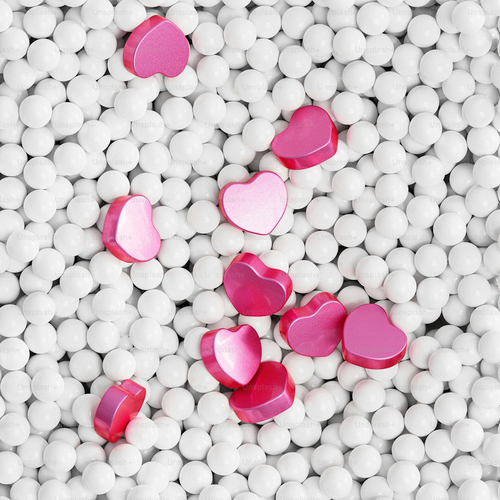 un montón de bolas blancas con corazones rosados en ellas