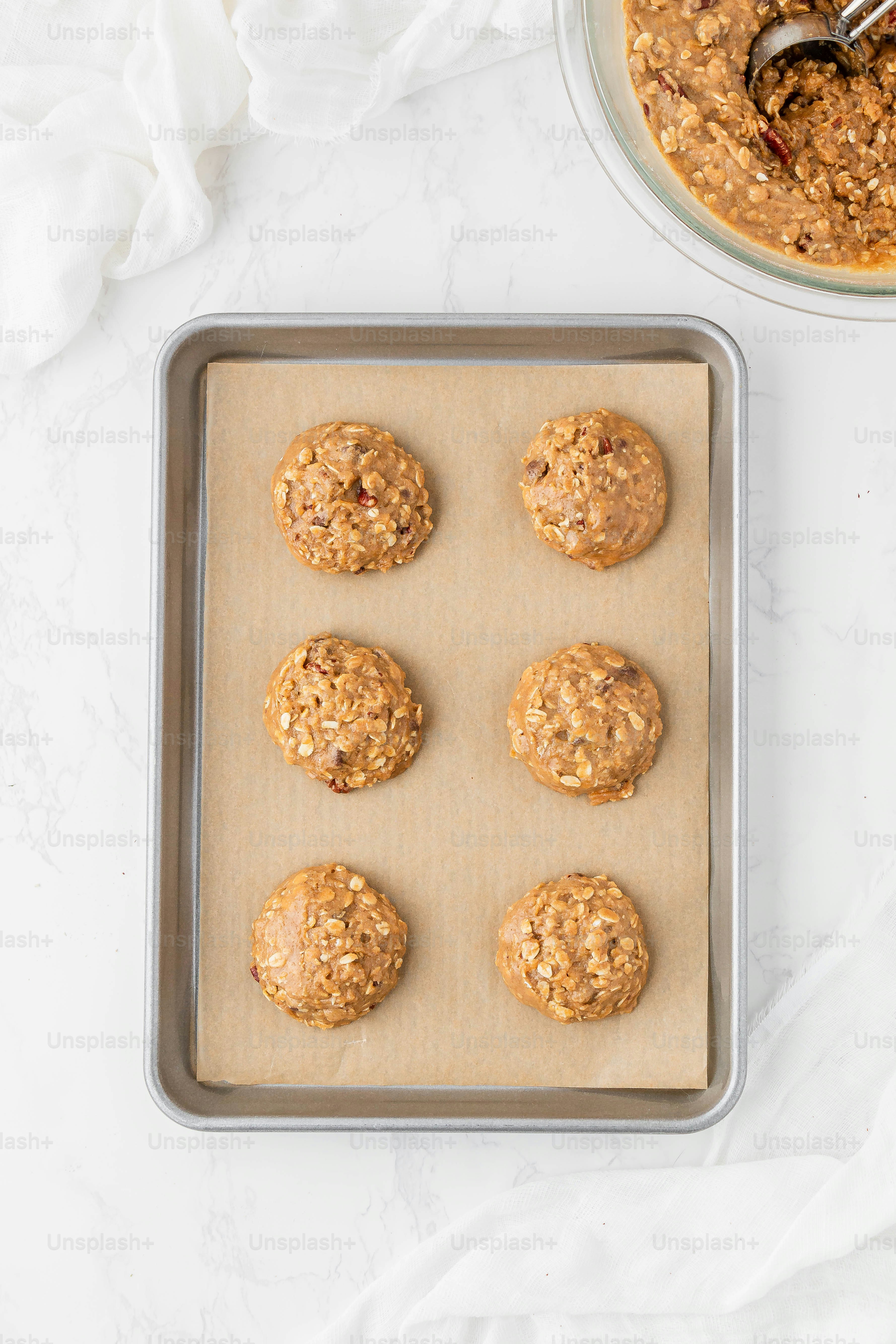 une poêle remplie de biscuits à l’avoine à côté d’un bol d’avoine