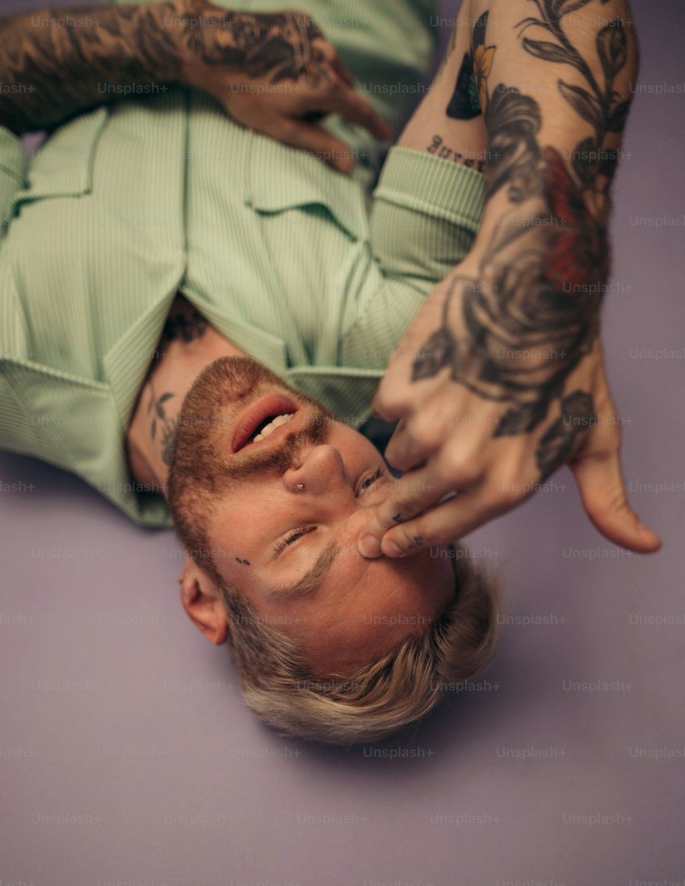 a man with tattoos laying on the ground