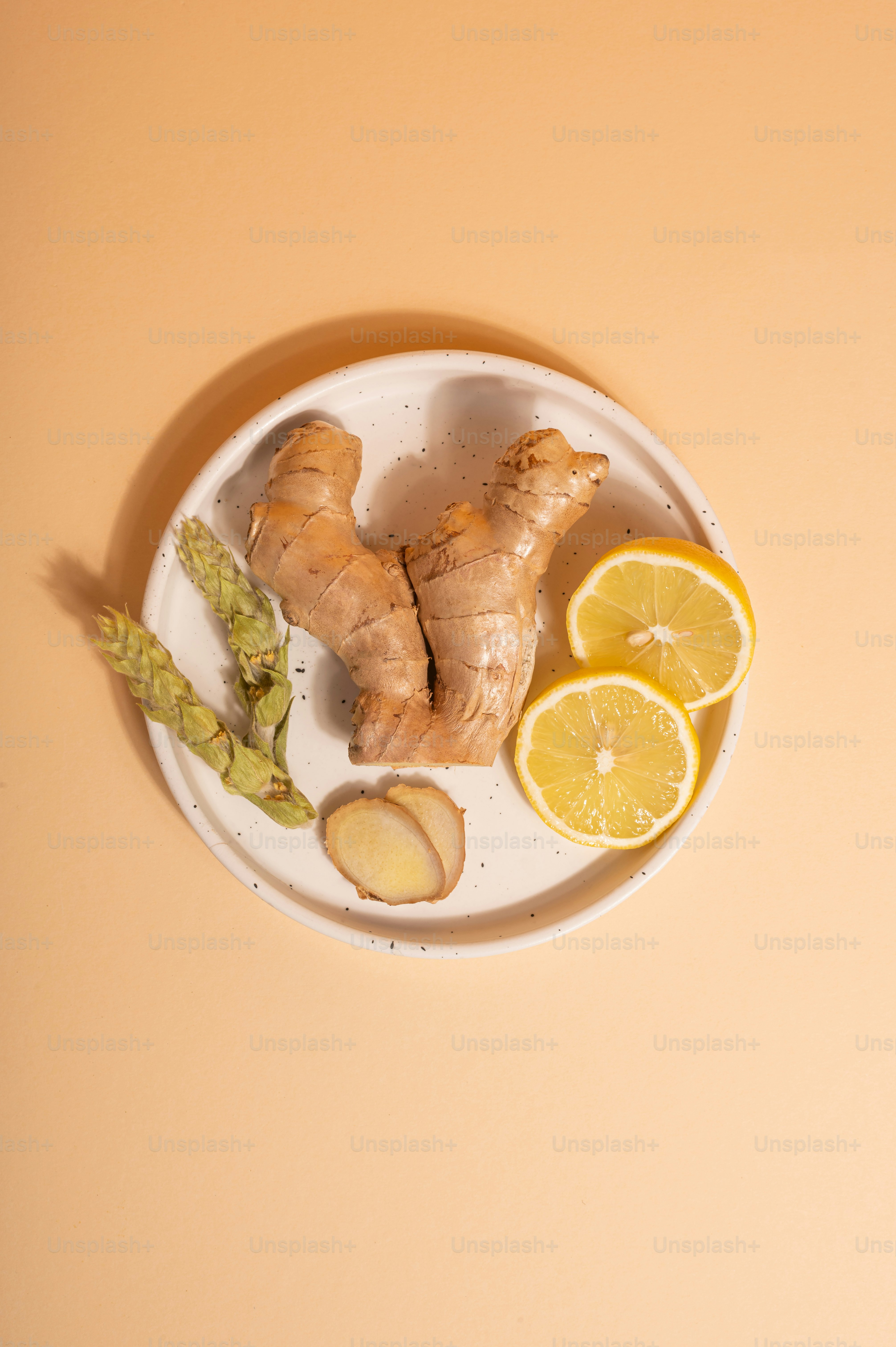a white plate topped with sliced up lemons and ginger