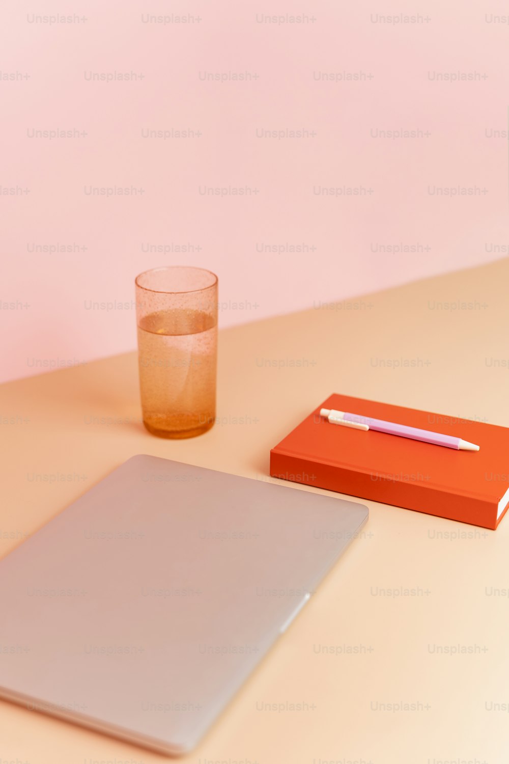 a glass of water and a notebook on a table