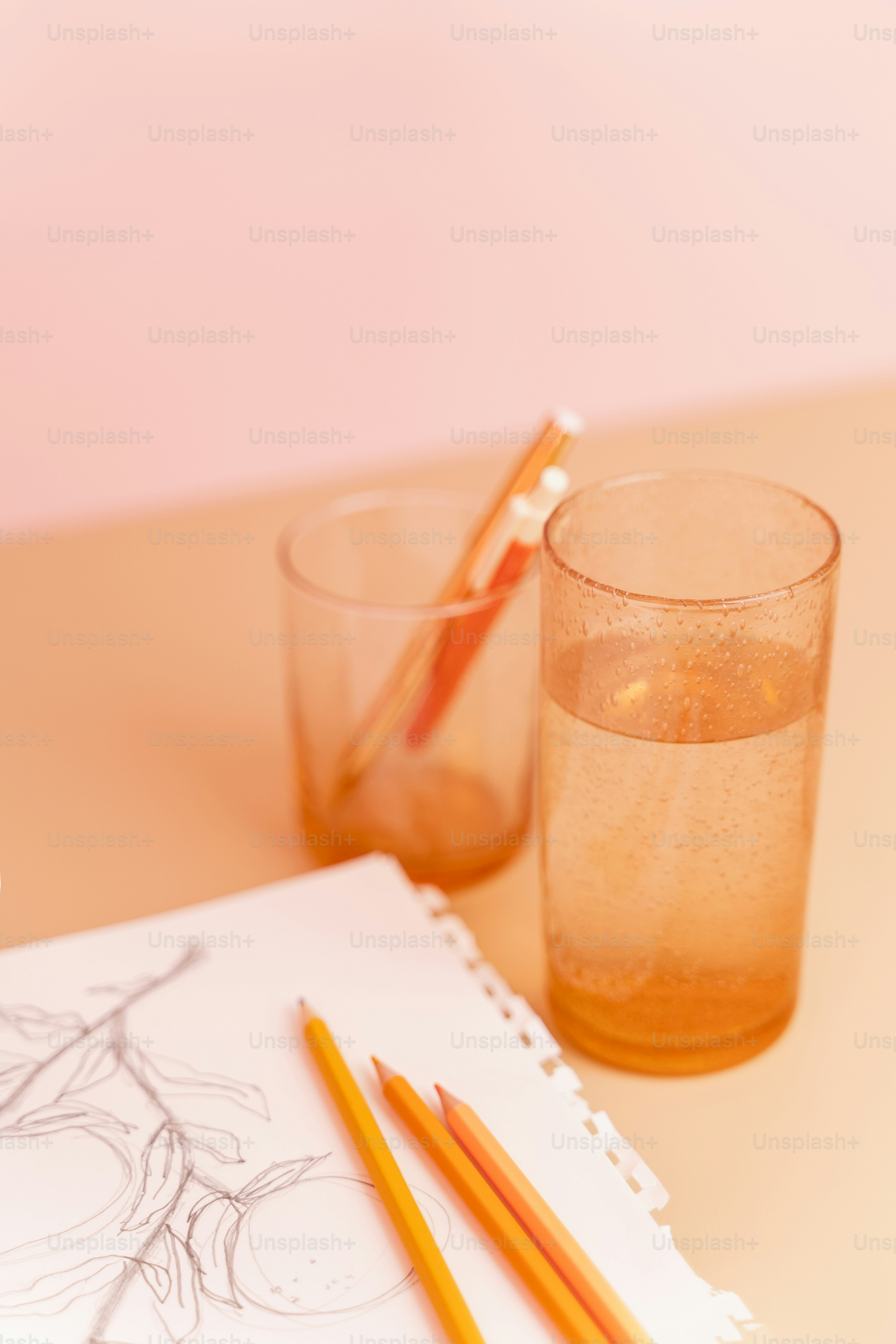 a pencil and a glass of water on a table