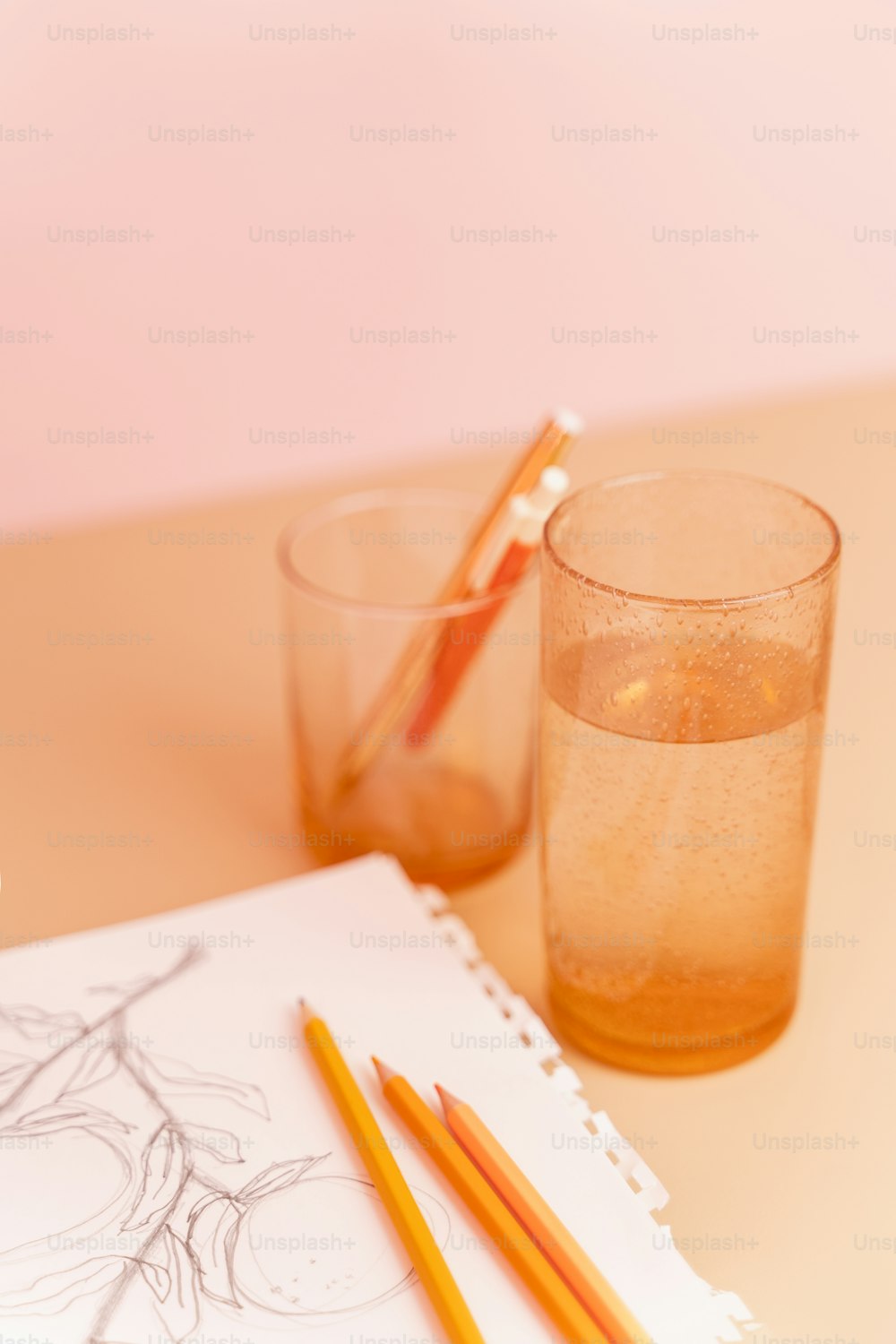 a pencil and a glass of water on a table