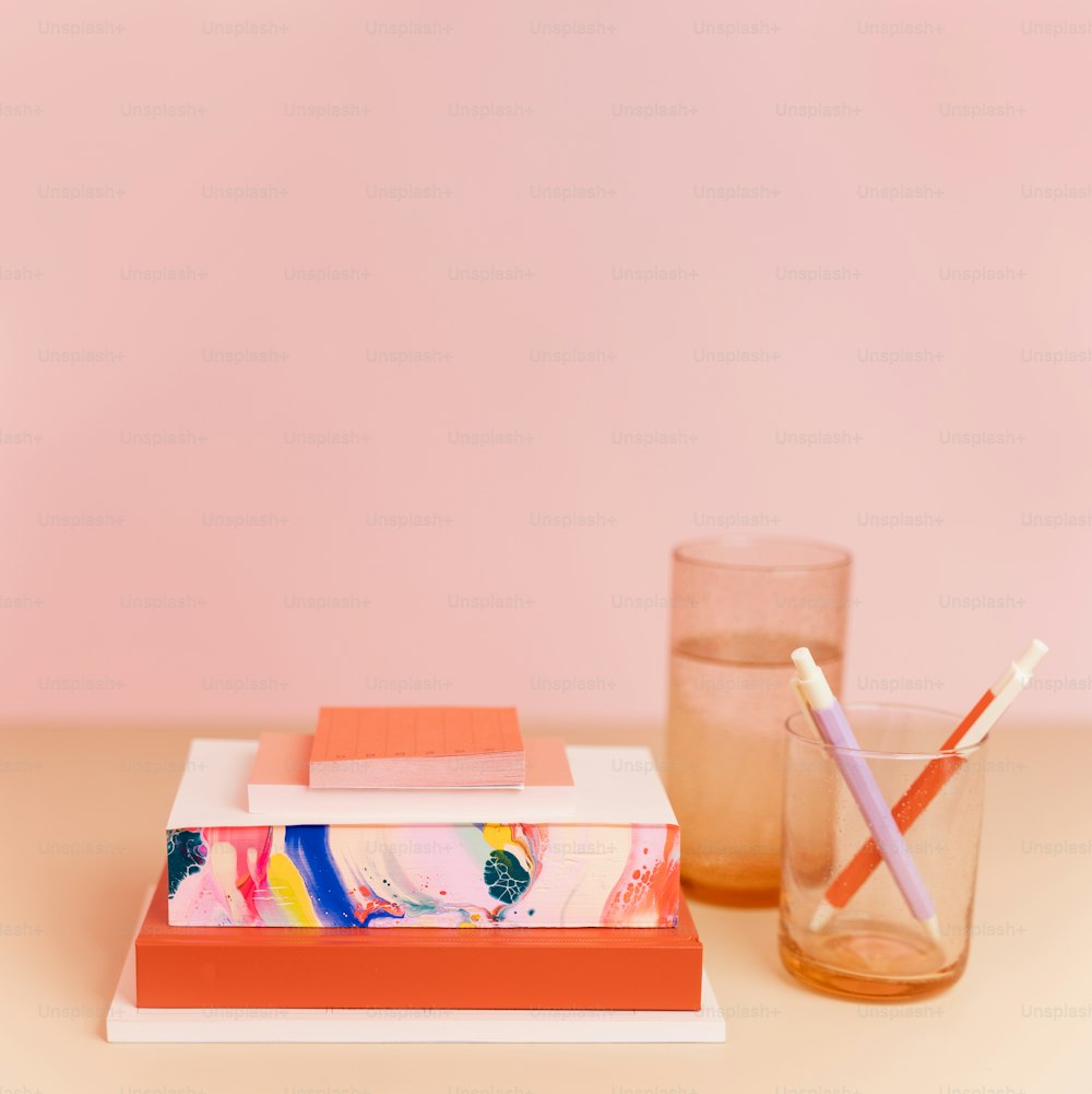 un verre d’eau et une pile de livres sur une table