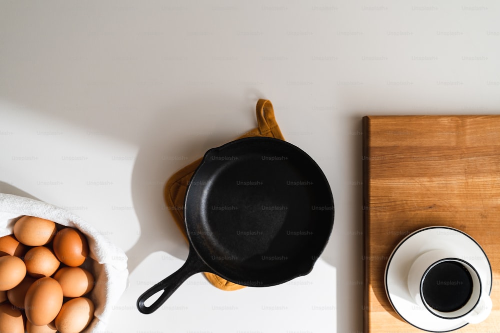 una tabla de cortar de madera cubierta con huevos junto a un tazón de huevos