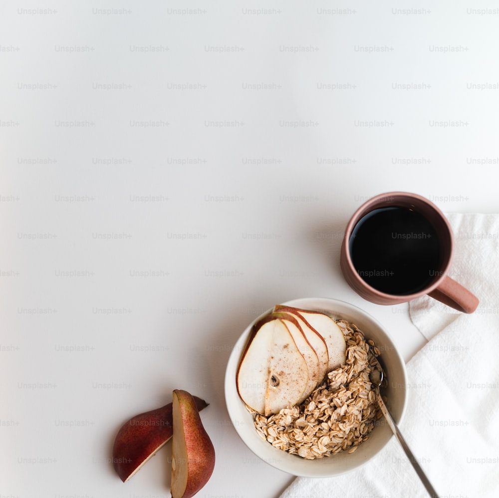 a bowl of oatmeal with apples and a cup of coffee