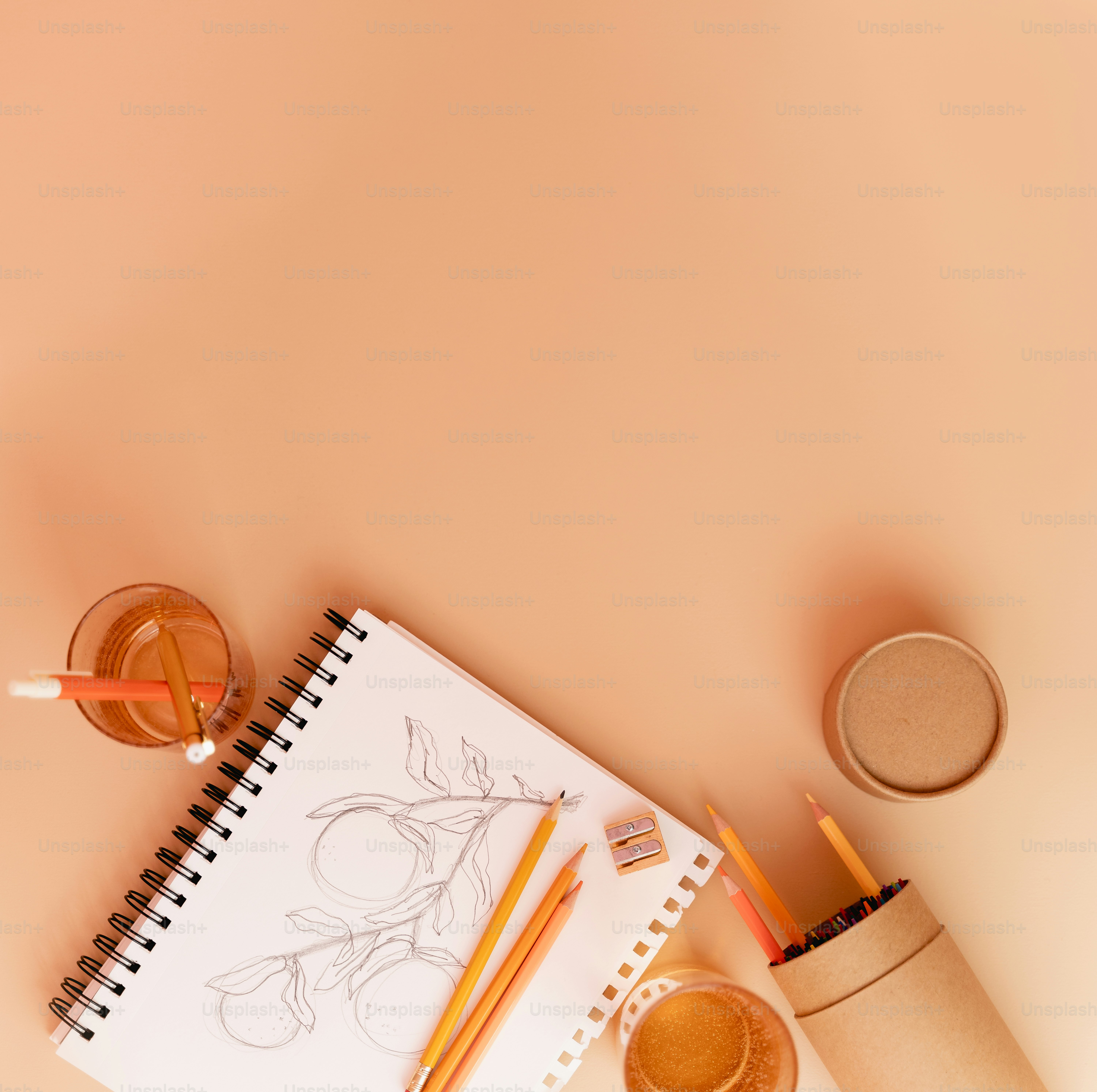 a notebook, pencils, and a cup of coffee on a table
