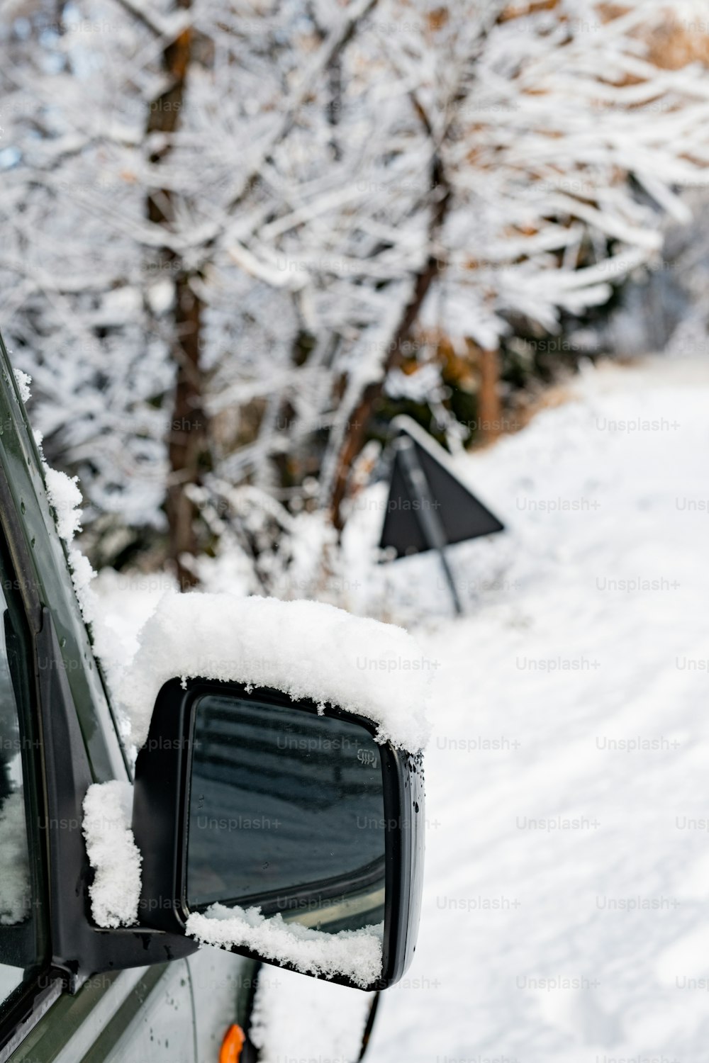 a car covered in snow sitting on the side of a road