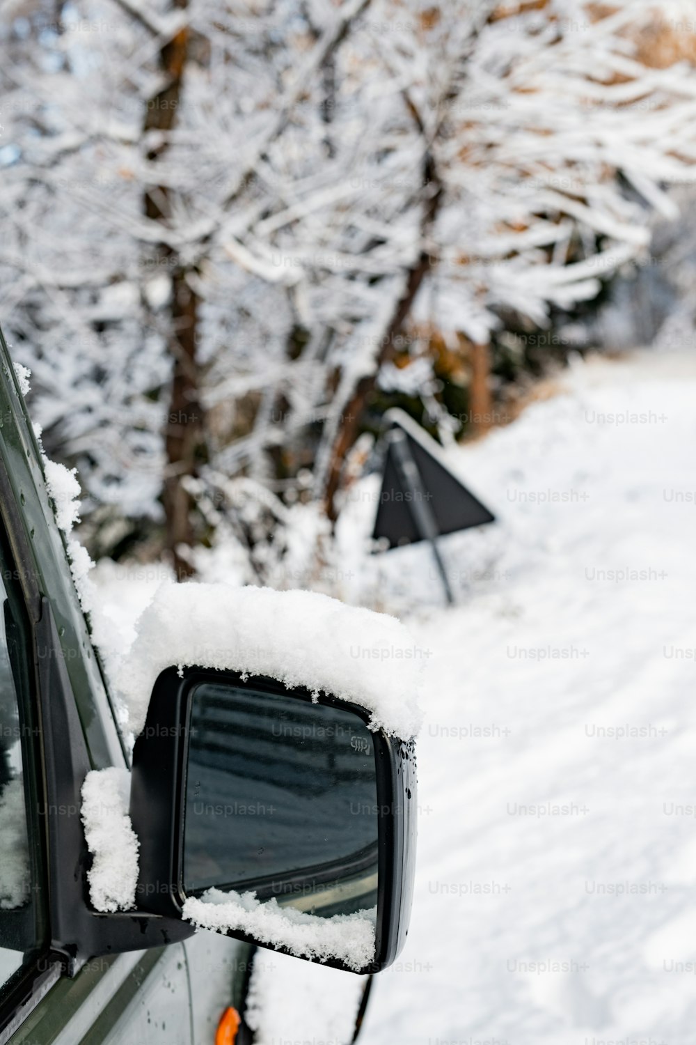 une voiture couverte de neige assise sur le bord d’une route