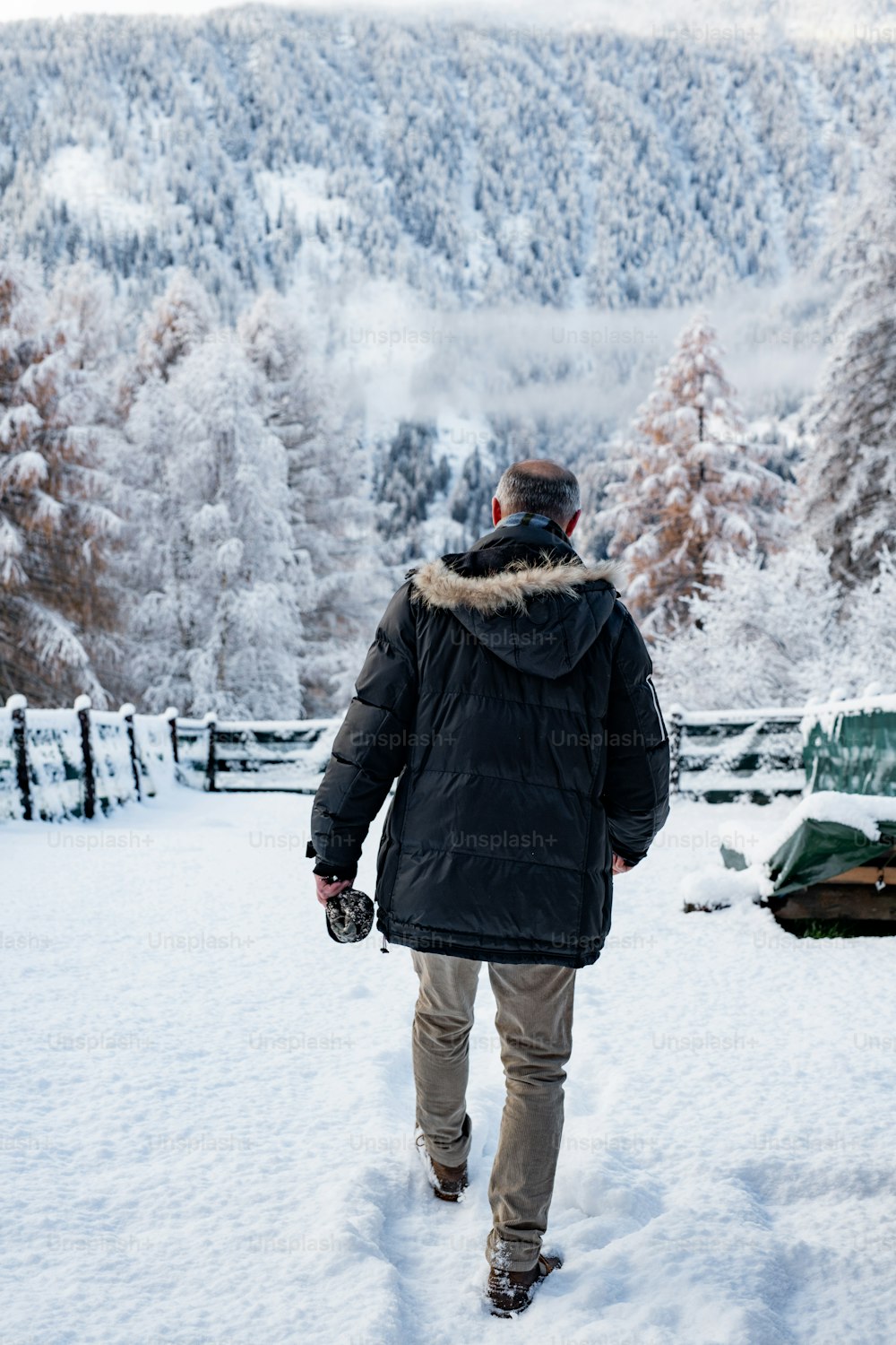 Un hombre caminando por la nieve en una parka