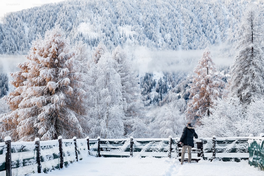 uma pessoa em pé em cima de uma encosta coberta de neve