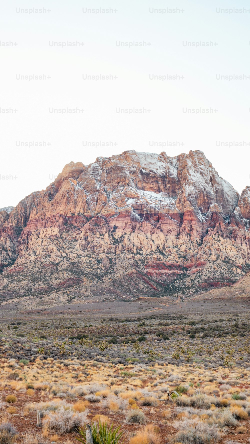 a mountain with a snow covered top in the desert