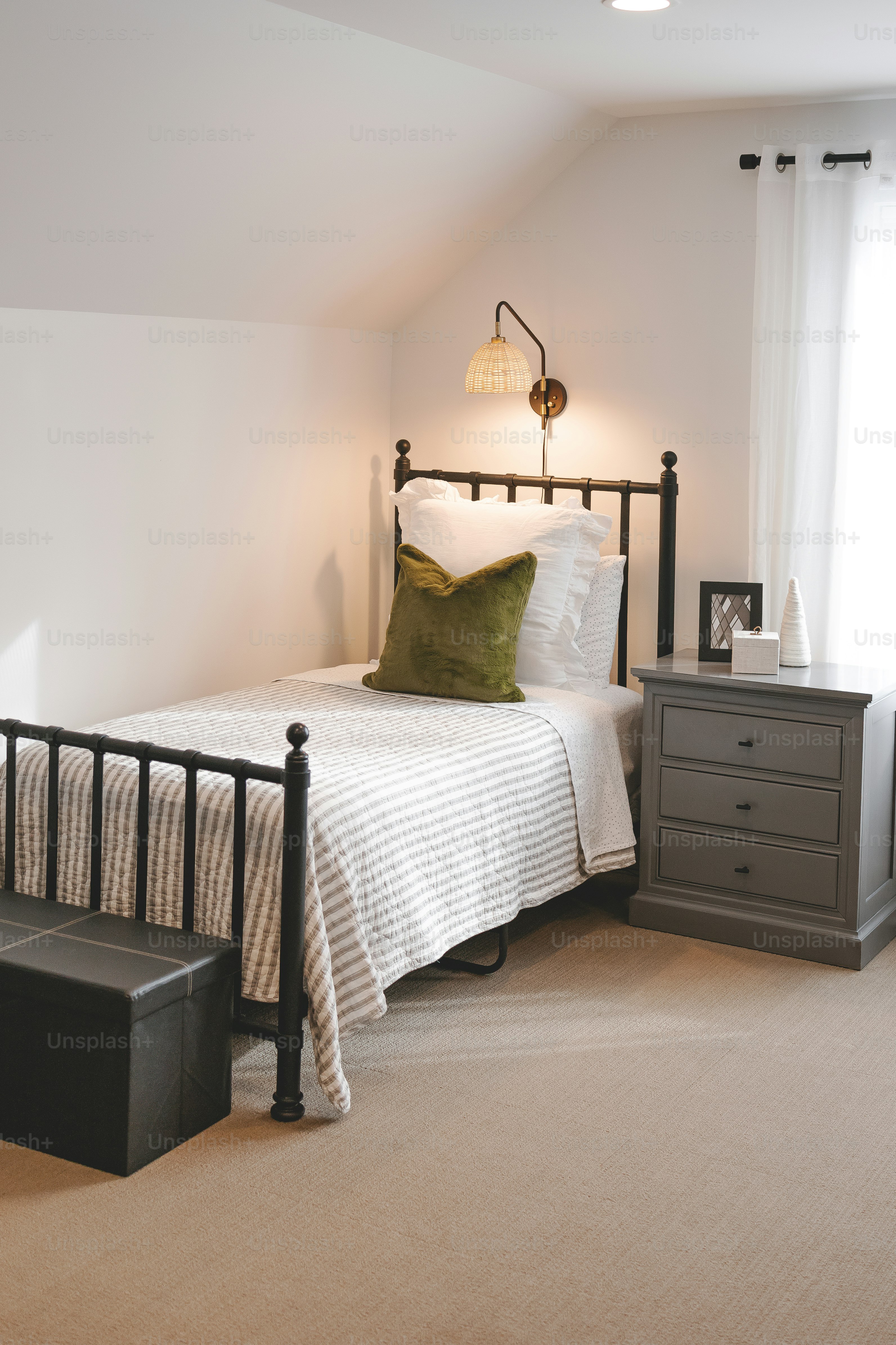 a bed sitting in a bedroom next to a window