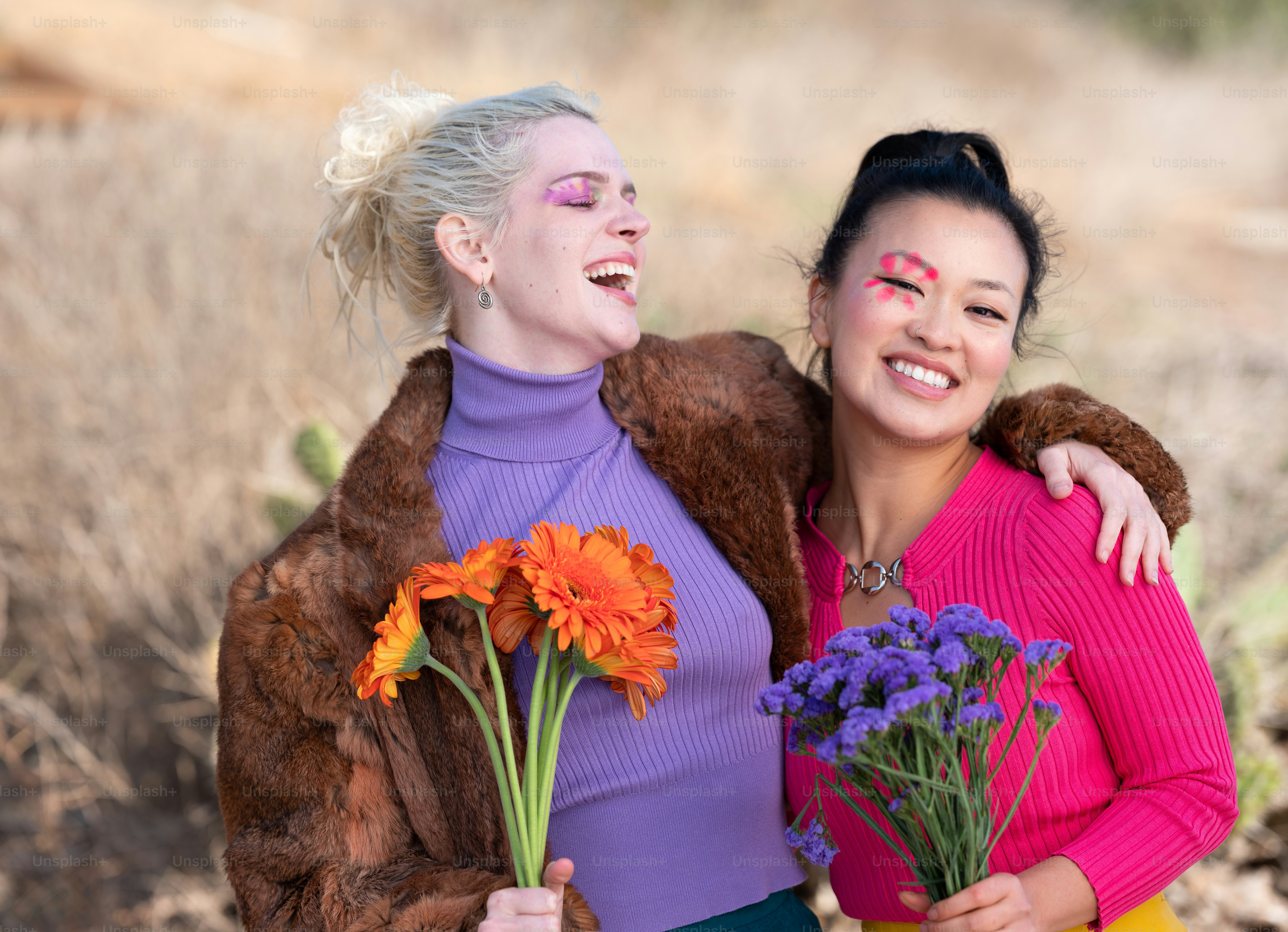 a couple of women standing next to each other holding flowers