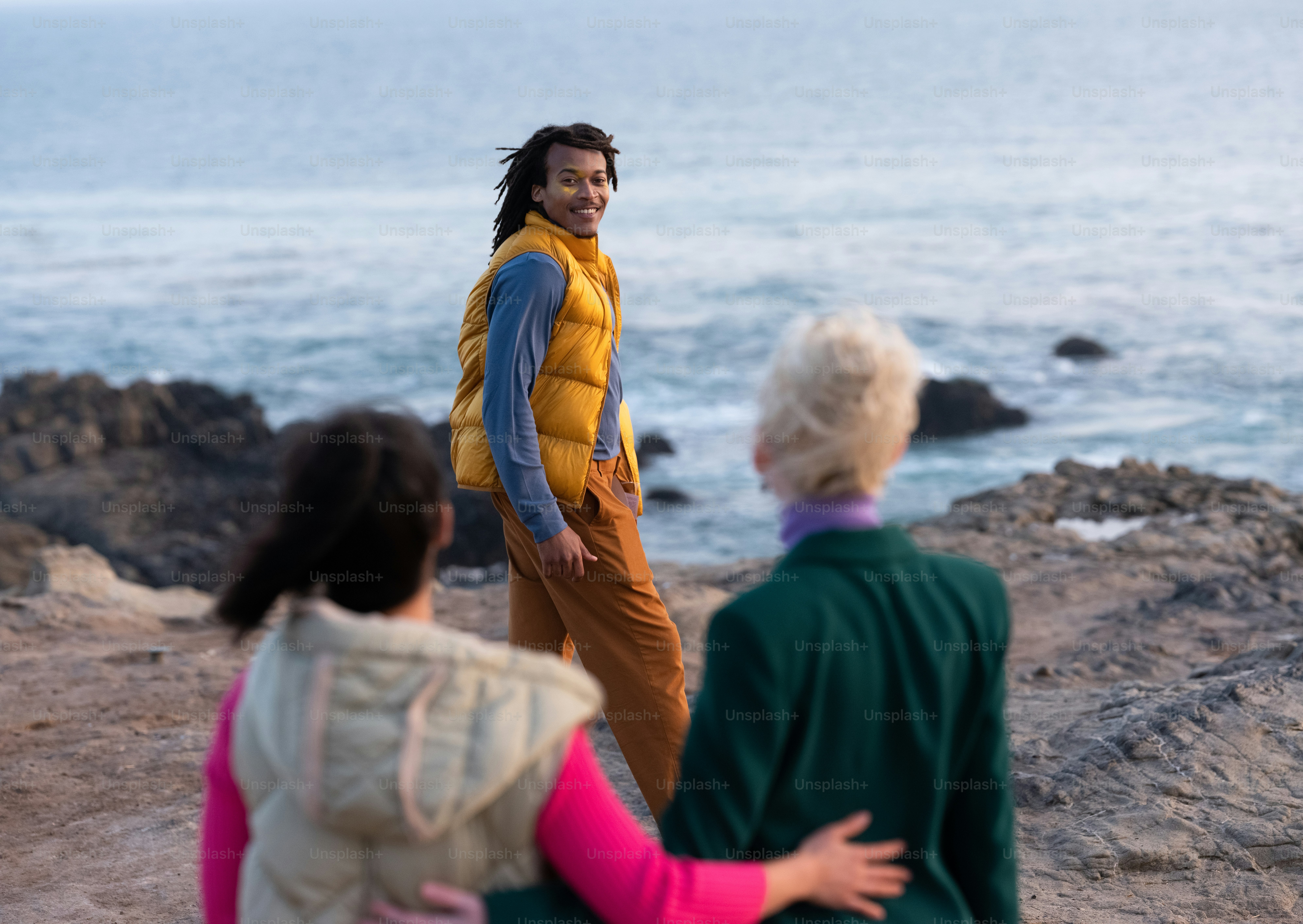 a group of people standing on top of a rocky beach