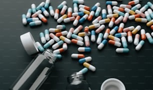 a pile of pills next to a bottle of medicine