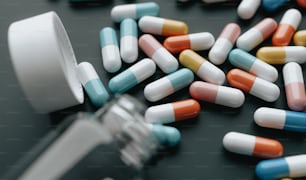 a close up of many pills and a glass of water