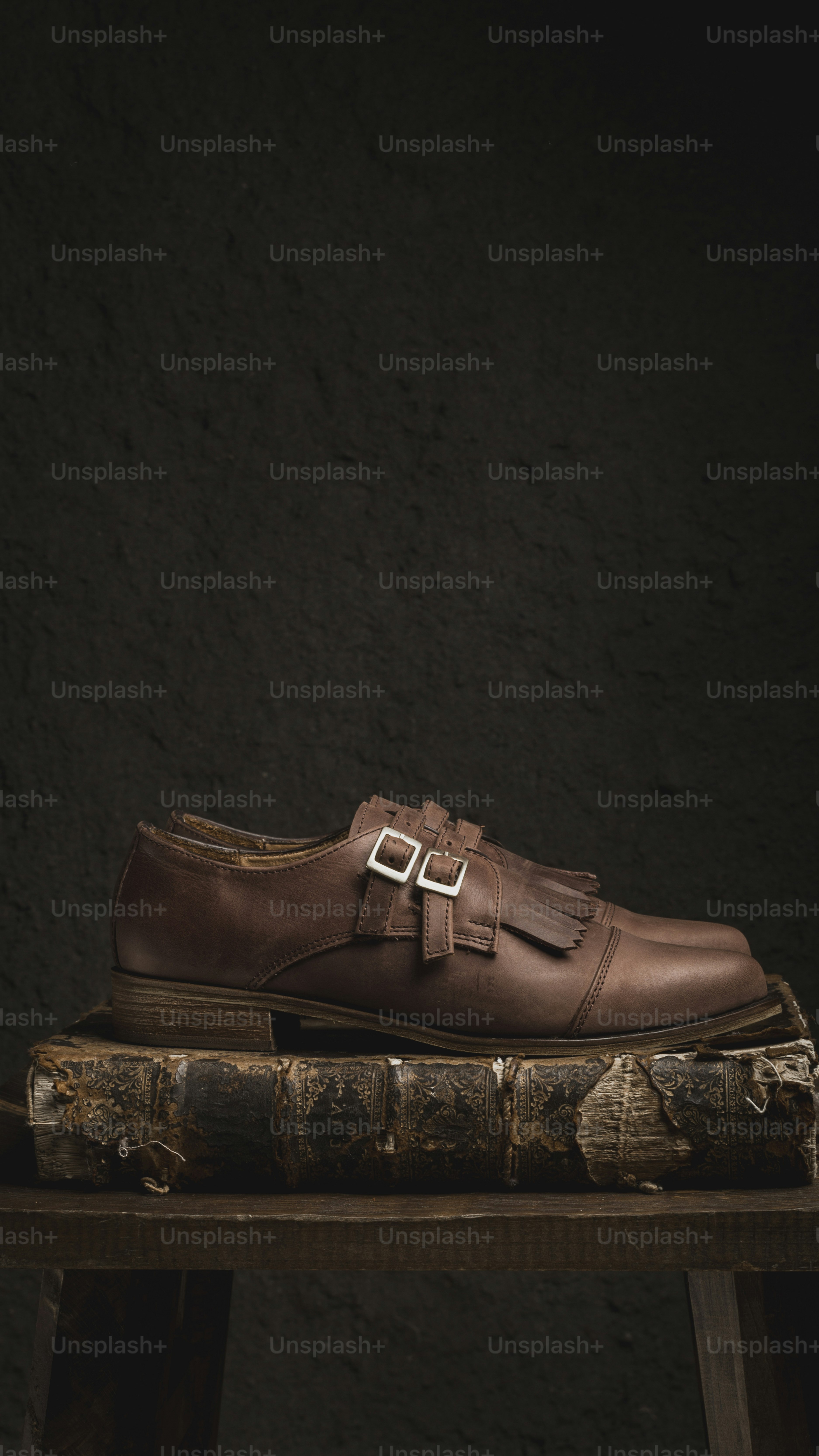 a pair of brown shoes sitting on top of a book