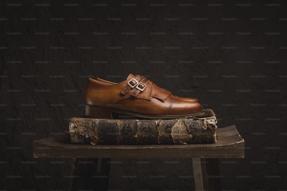 a pair of brown shoes sitting on top of a book