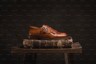 a pair of brown shoes sitting on top of a book