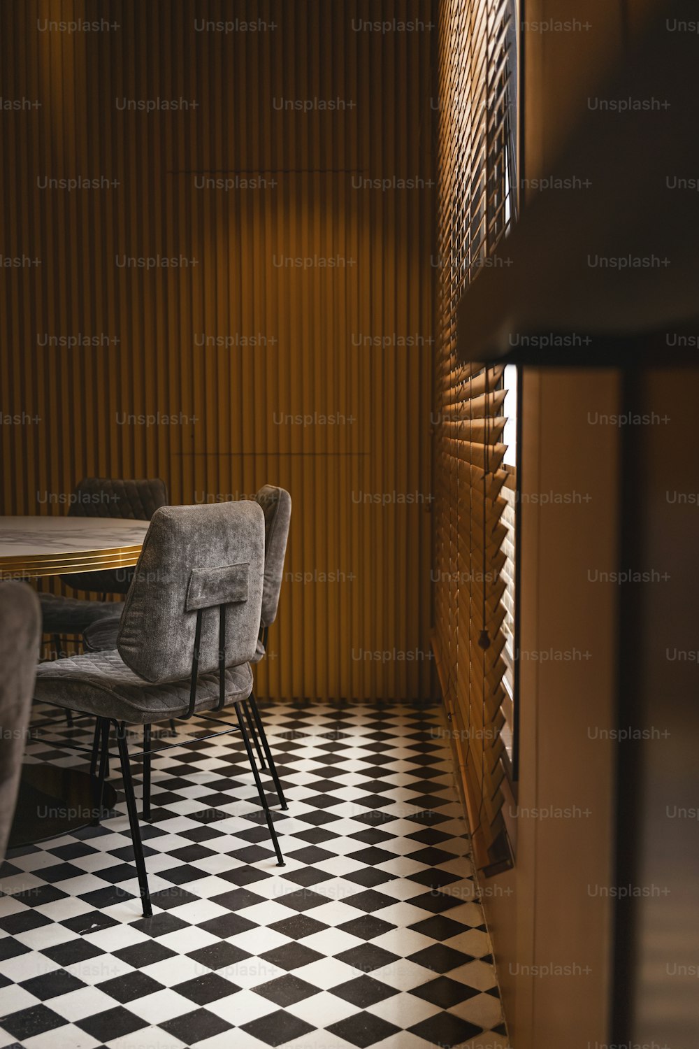 체크 무늬 바닥과 테이블과 의자가있는 방