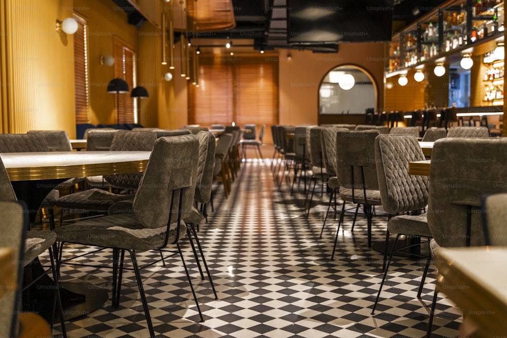 um restaurante com piso quadriculado e mesas e cadeiras