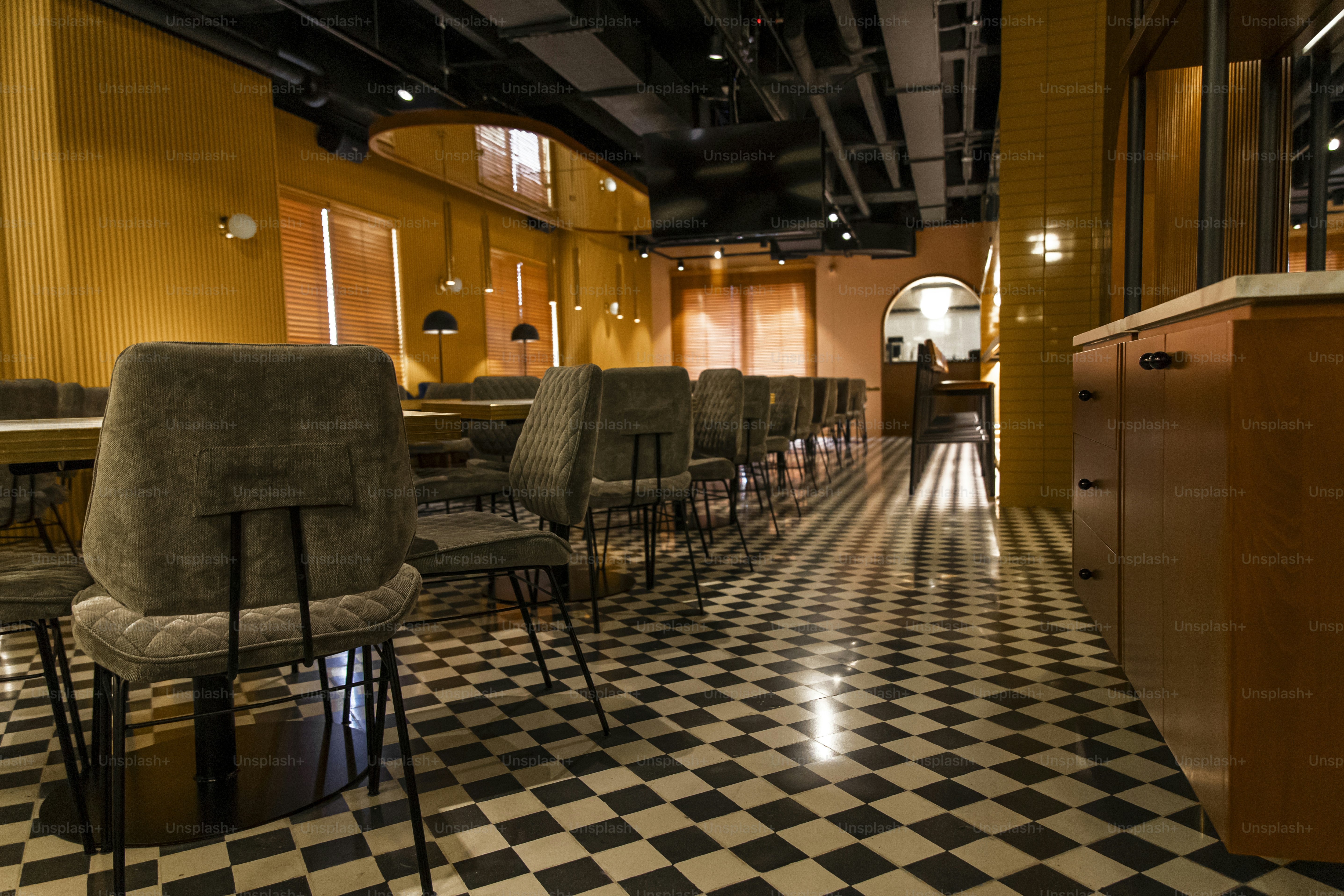 une chambre avec un sol en damier et des chaises