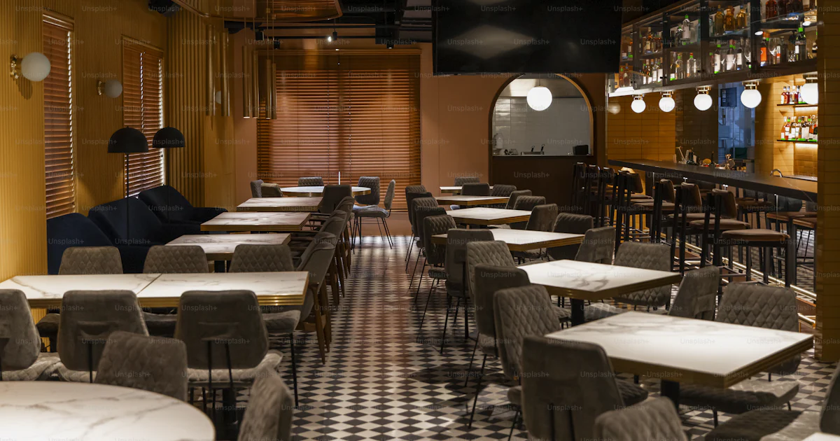 A restaurant with a checkered floor and yellow walls photo – Interior ...