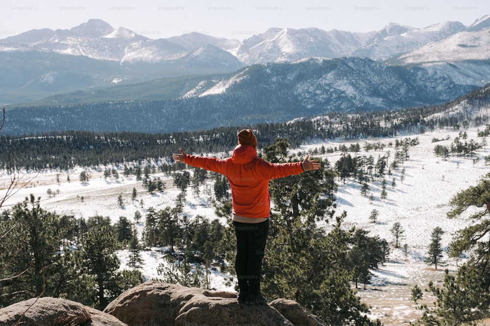 a person standing on top of a mountain with their arms outstretched