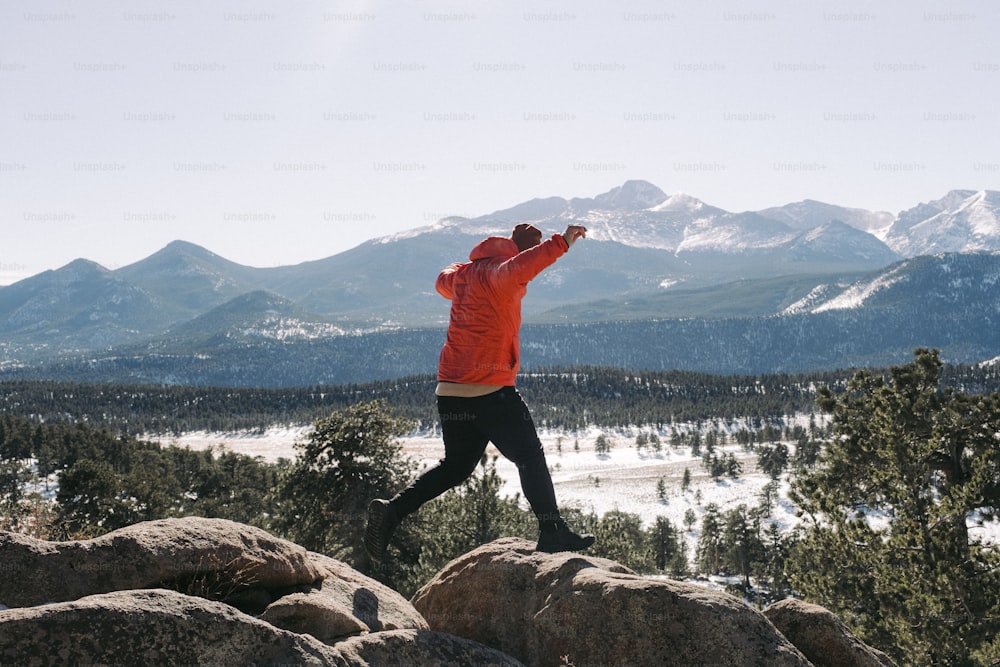 a man standing on top of a large rock