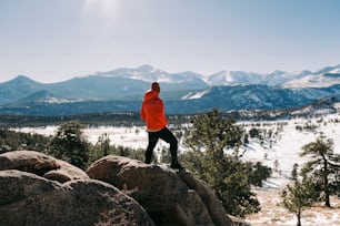 a man standing on top of a large rock