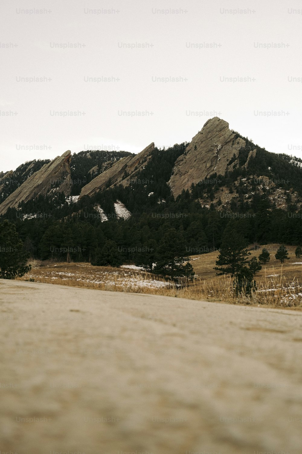 a dirt road with a mountain in the background