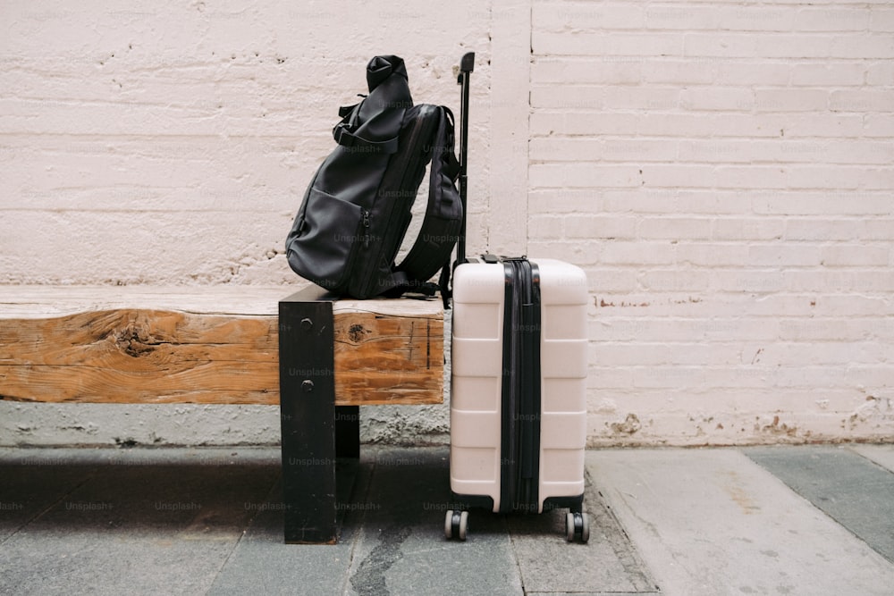 a piece of luggage sitting on top of a wooden bench