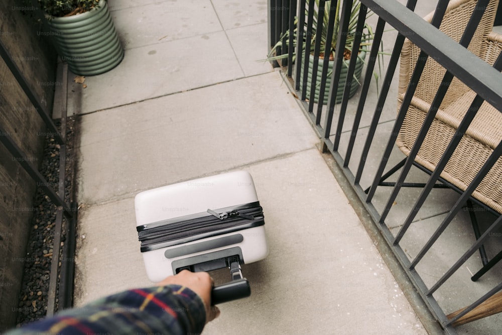 une personne pousse une valise dans les escaliers