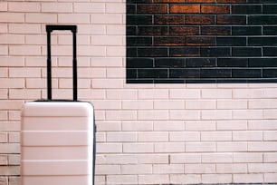 a piece of luggage sitting in front of a brick wall