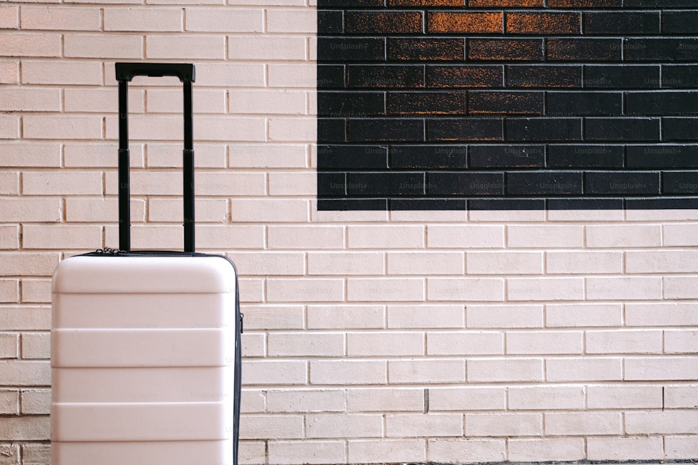 a piece of luggage sitting in front of a brick wall