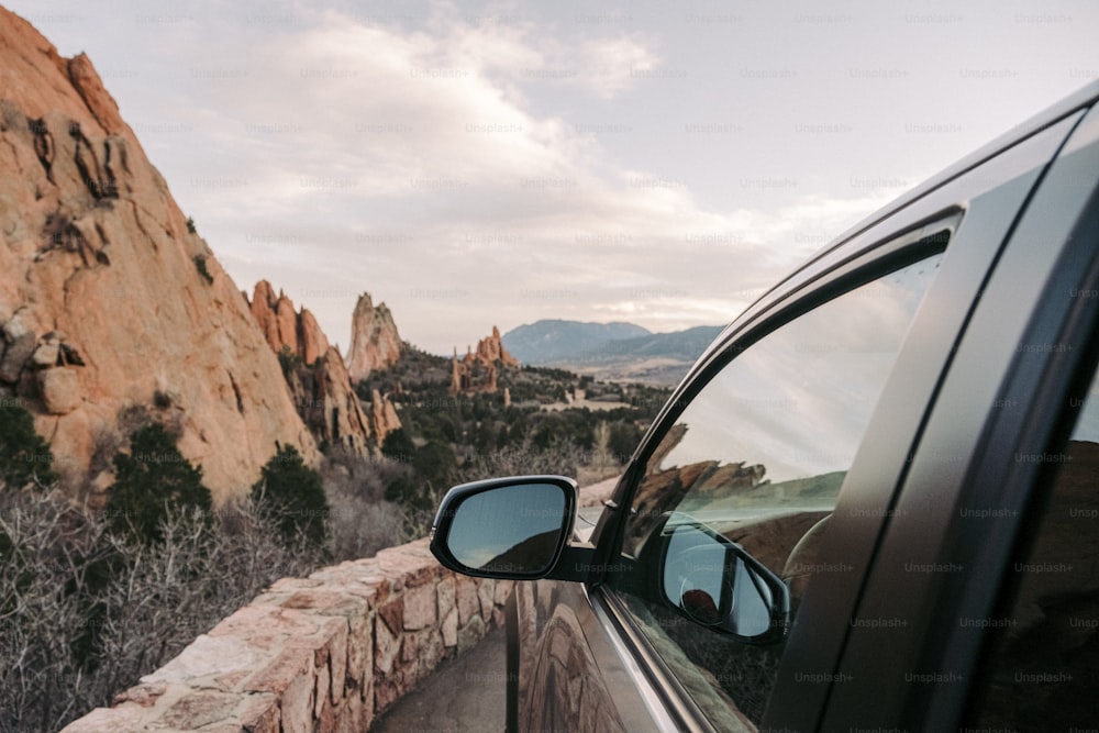 a car parked on the side of a road next to a mountain